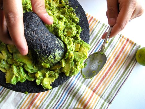 Mashing avocados in the molcajete Mashing avocados in the molcajete