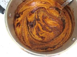 Adding the pureed spices, tomatoes, and onions to the chile puree Adding the pureed spices, tomatoes, and onions to the chile puree