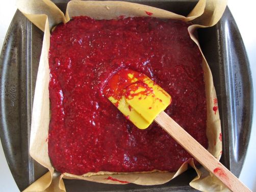 Spreading out the raspberry layer of Raspberry Blood Orange Bars Spreading out the raspberry layer of Raspberry Blood Orange Bars